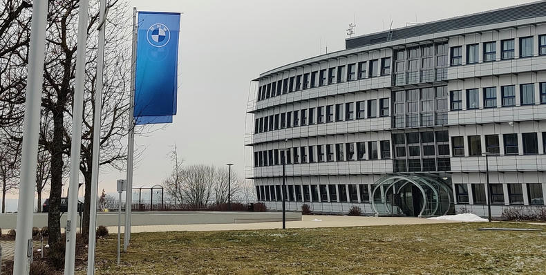The front of an office building with two BMW flags